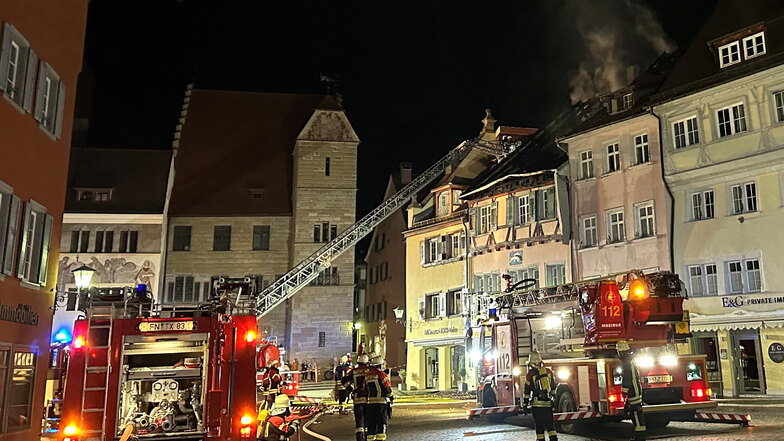 Feuerwehrleute löschen den Brand in dem Dachstuhl eines Hauses. In der baden-württembergischen Stadt Überlingen sind durch einen Großbrand mehrere Gebäude stark beschädigt worden.