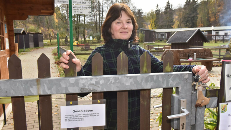 Kassiererin Sylvia Meißner schließt wegen der Corona-Schutzmaßnahmen das Tor zum Wildpark Geising.