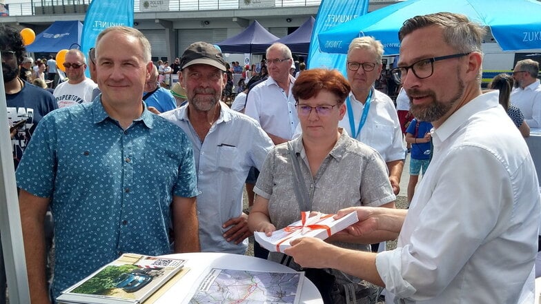 Markus Ahnert (links) und Berit Wittke vom Milkauer Heimatverein haben dem Staatsminister für Wirtschaft, Arbeit und Verkehr Martin Dulig (SPD) die Unterschriftensammlung zur Radwegführung übergeben.