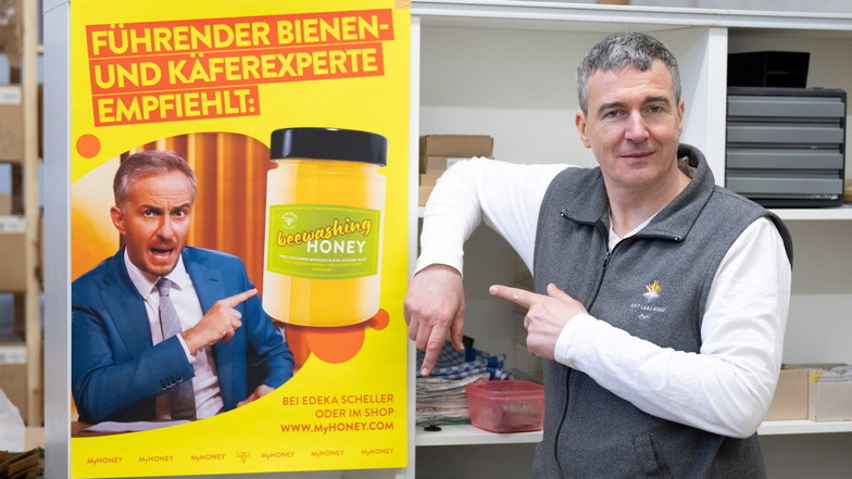 Rico Heinzig steht neben einem Plakat mit dem Foto des Moderators Jan Böhmermann.