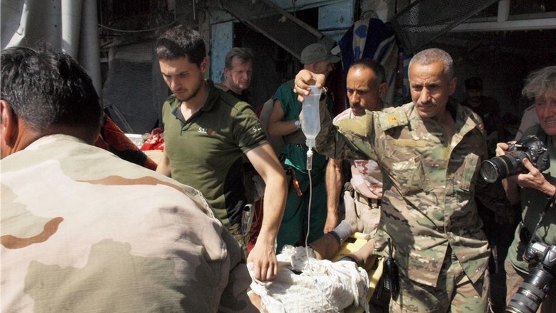 Irakische Soldaten bringen Verletzte in das Lazarett, das früher mal eine Metzgerei war.