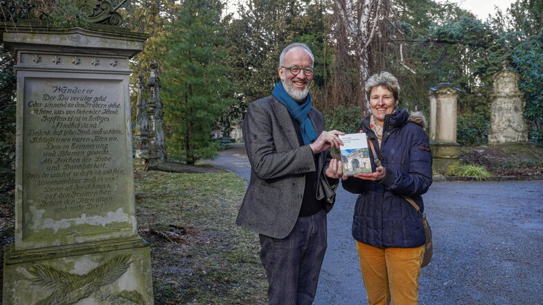 Pfarrer Christian Tiede und Grit Richter-Laugwitz, Leiterin des Archivverbunds Bautzen, zeigen das Buch zum 500-jährigen Bestehen des Taucherfriedhofs.