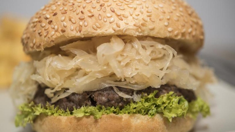 Sauerkraut gibt einem klassischen Burger eine fruchtig-säuerliche Note. Foto: Robert Günther/dpa-tmn
