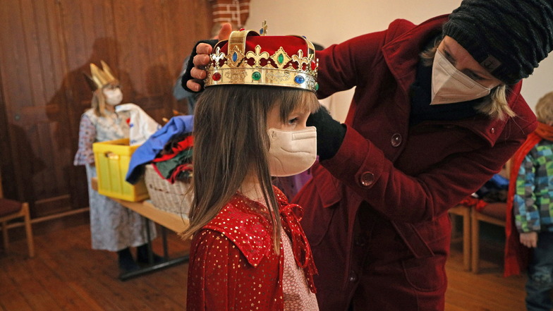 Sitzt alles? Organisatorin Susann Ossmann passt der neunjährigen Anne in der Riesaer Trinitatiskirche die Sternsinger-Krone an.