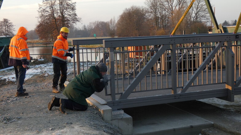 Die Aluminium-Brücke, die jetzt am Verteilerwehr in Spreewiese montiert worden ist, misst knapp 15 Meter und wiegt nur knapp vier Tonnen. Ein Kran hievte sie an die richtige Stelle, wo sie passgenau in das Widerlager eingefügt wurde.