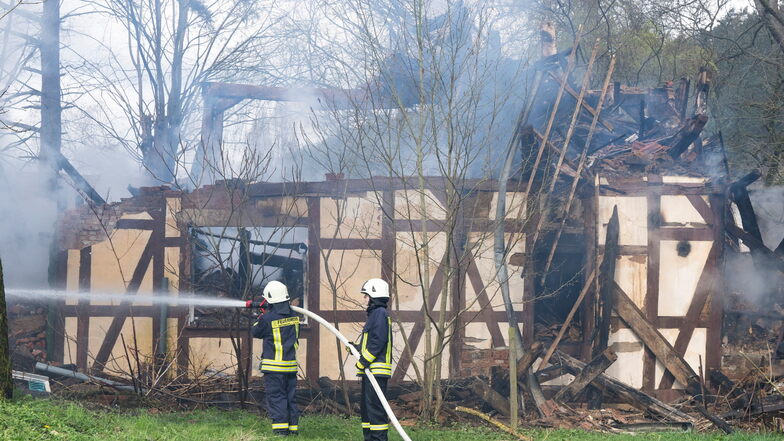 Feuerwehrleute löschen in Wüstefeld bei Rotenburg die noch rauchenden Trümmer des ehemaligen Hofes des "Kannibalen von Rotenburg".