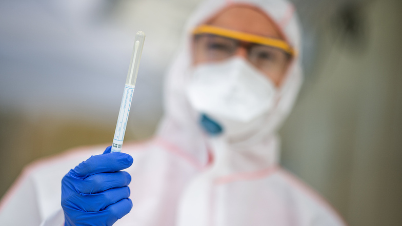 Ein Mitarbeiter hält einen Abstrich in der Hand, der benutzt wird, um einen Test auf das Coronavirus durchzuführen.