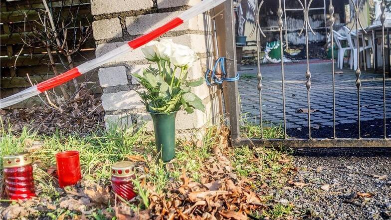 Vor Ort bekunden Menschen mit Kerzen und Blumen ihre Anteilnahme am Tod eines 48 Jahre alten Gröditzers. Er war am Freitag mit seinem Hund in den Flammen ums Leben gekommen.