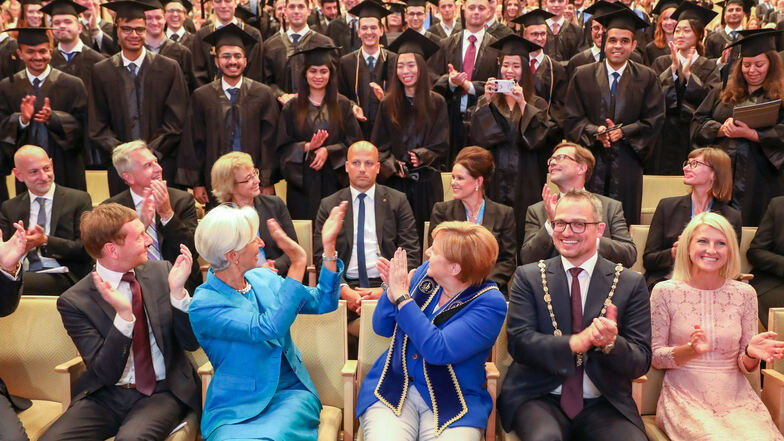 Merkel, Lagarde und Kretschmer beglückwünschen die Absolventen der Leipziger Handelshochschule.