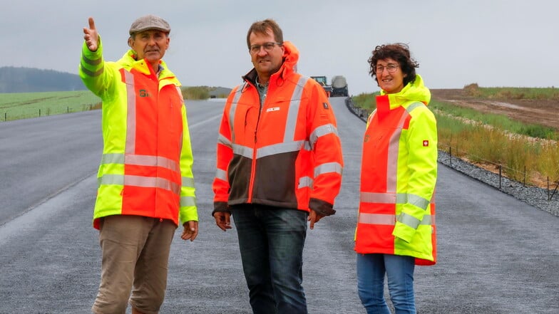 Volker Fuhrmann (links) und Kerstin Gallasch (rechts) vom Planungsbüro Bit, das für die Bauüberwachung zuständig ist, sowie Bernd Just vom Lasuv nehmen die Asphaltierung der neuen B178 in Augenschein.