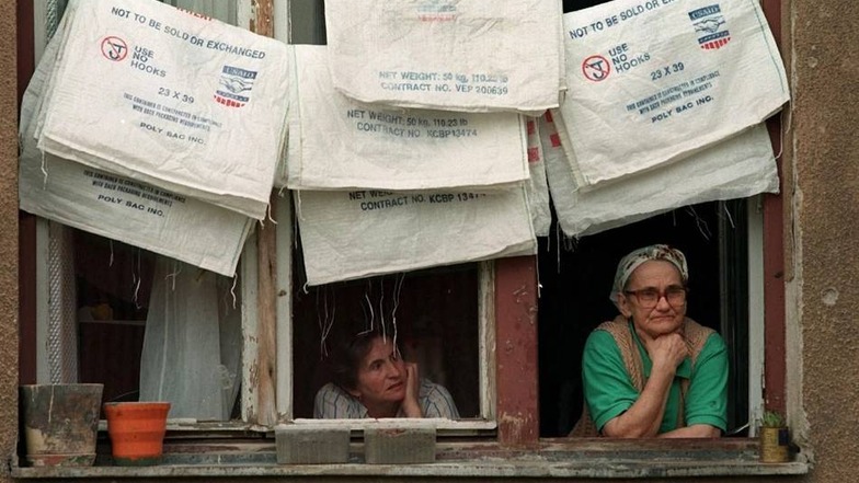 Im Mai 1996 blicken zwei bosnische Flüchtlingsfrauen in einem Flüchtlingslager in Sarajevo aus dem Fenster.