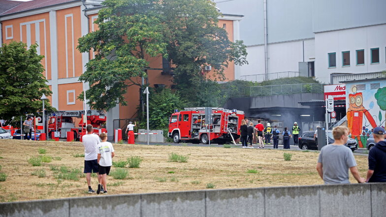 Passanten beobachten aus Richtung Elbstraße Löscharbeiten der Feuerwehr an der Riesaer Elbgalerie.