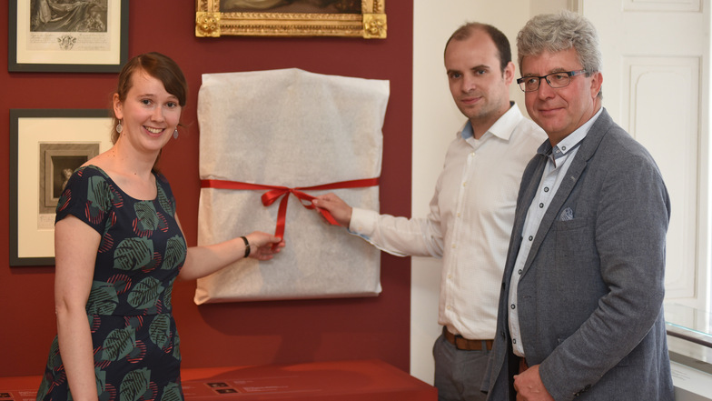 Anja Schumann, Leiterin des Damastmuseums, Marian Hensky, Vorstand der Ingrid-Bischof-Stiftung, und Bürgermeister Frank Peuker (von links) mit einem der Bilder.