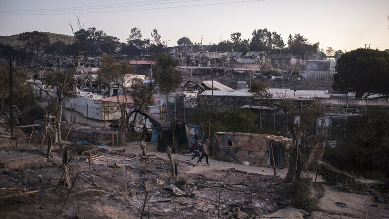 Asylsuchende laufen Mitte September durch die Trümmer des abgebrannten Flüchtlingslagers Moria.