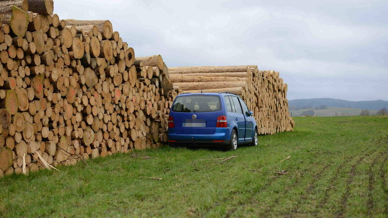 Der VW Touran hat hinter einem Holzstapel gestanden.