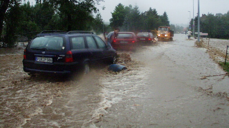 12. August 2002: Autos bahnen sich mühsam den Weg über die von der Seidewitz überflutete Liebstädter Straße in Pirna-Zuschendorf.