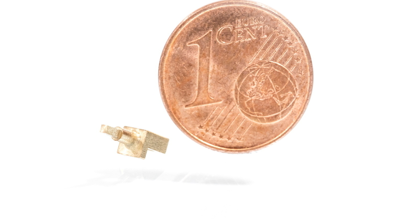 Das kleinste bei der GMT GmbH gefertigte Bauteil im realen Größenvergleich zu einer 1-Cent-Münze.