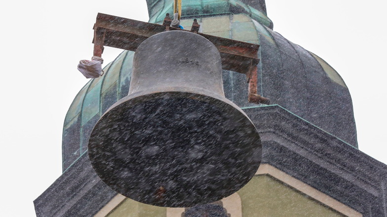 Hier wird eine der Glocken herausgehoben - und das bei Schneeregen.