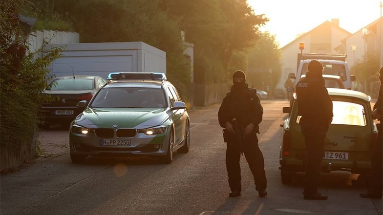 Spezialkräfte der Polizei sperren in Ansbach die Zufahrt zu einem Flüchtlingsheim, in dem ein 27-Jähriger gewohnt haben soll.