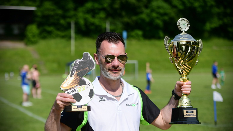 Der Kickfixx-Präsident Thomas Wockatz präsentiert die begehrten Pokale zum Fußballturnier.