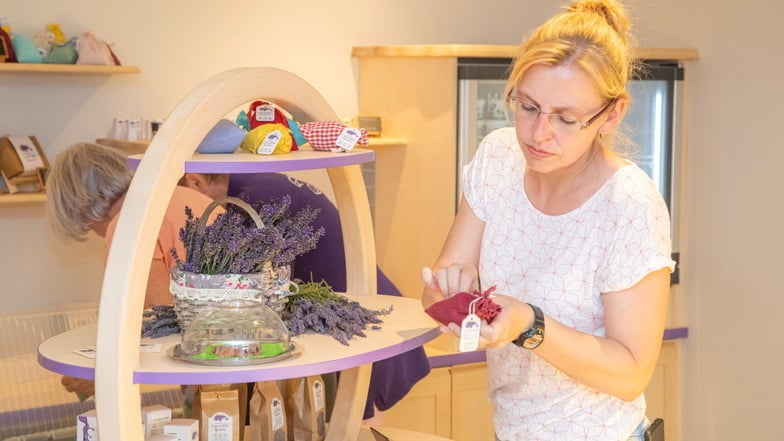 Mitarbeiterin Veronika Fritsche dekoriert das einem großen Korb ähnelnde Regal im neuen Laden mit Lavendelprodukten.