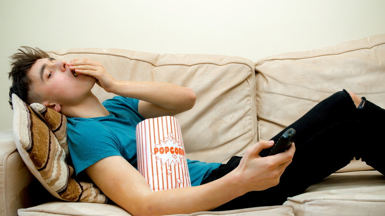 Dieser Homie
ist sowas von
cringe: Hängt schön auf der Couch ab und krümelt sich
mit Popcorn voll.