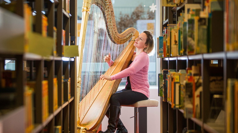Mozart zwischen Bücherregalen: Sarah Christ erweckt die verwaiste Bibliothek im Kulturpalast mit Harfenklängen zum Leben.