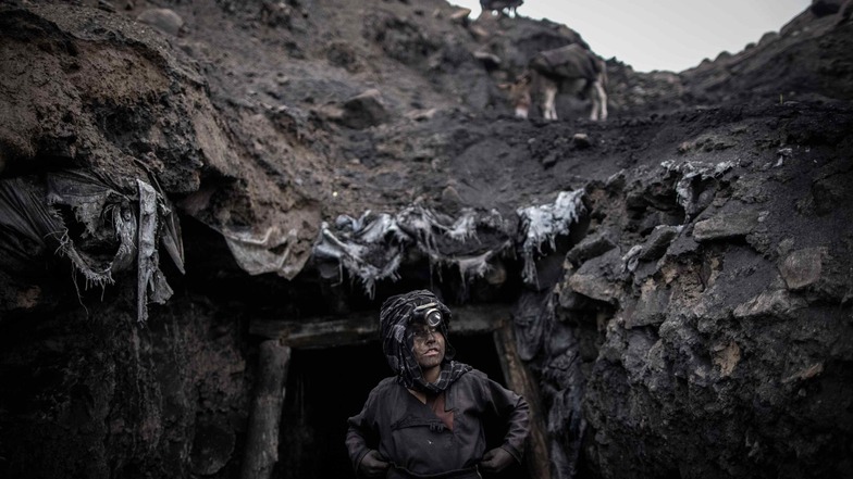 Ein Junge, der als Bergarbeiter arbeitet, steht vor einem informellen Kohlebergwerk in Chinarak in der afghanischen Provinz Baghlan.