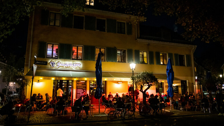 Freitagabend in Freiburg: Trotz kühler Temperaturen sitzen Menschen draußen vor einem Restaurant.