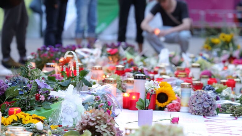 Nach der Messerattacke auf dem Solinger Stadtfest legen Menschen in der Nähe des Tatortes Blumen nieder und und zünden Kerzen zum Gedenken der Opfer an.