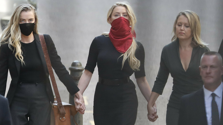 Amber Heard (M), Schauspielerin aus den USA, trifft mit ihrer Schwester Whitney Heard (l) am High Court ein.