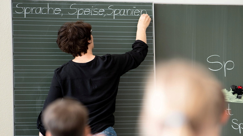 Eine Lehrerin schreibt in einer Schule Worte an eine Tafel. Manchen Kindern fällt selbst das richtige Abschreiben schwer. Grund, sich Sorgen zu machen?