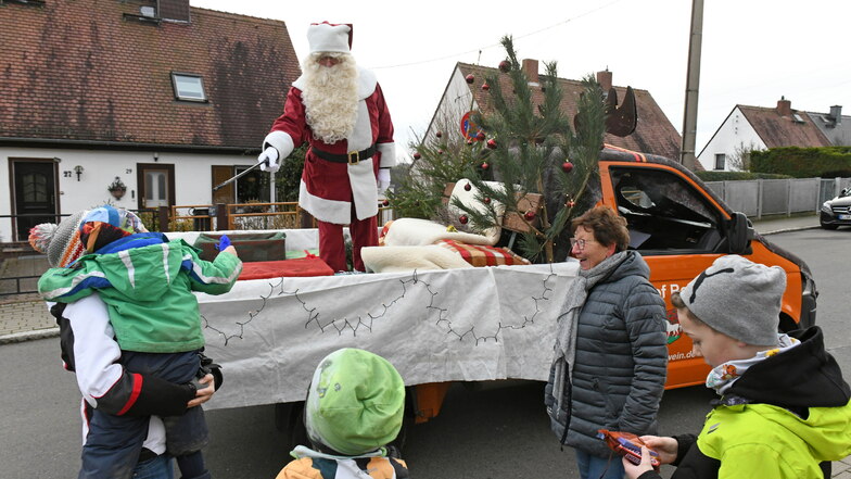 Die Kinder warteten am Straßenrand auf den Weihnachtsmann, der vom Elch-Mobil mit einem Greifer Geschenke verteilte.