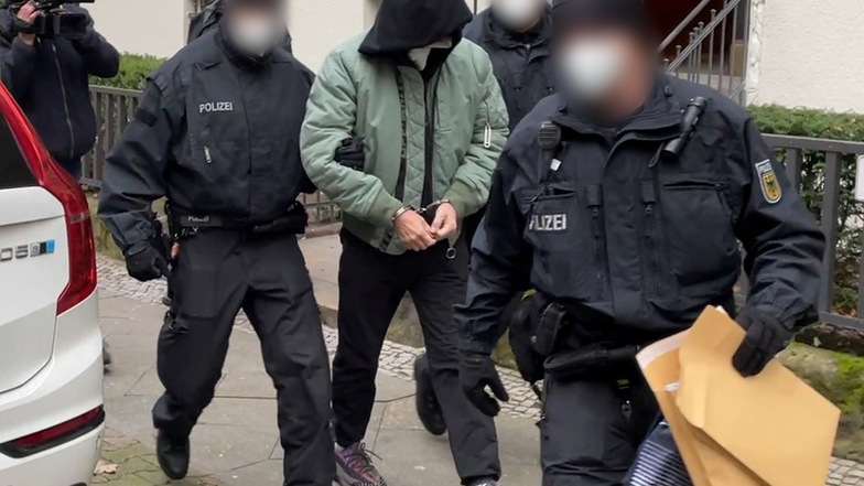 Bei einer Razzia in mehreren Bundesländern, darunter Berlin, führen Bundespolizisten einen festgenommene Mann ab.
