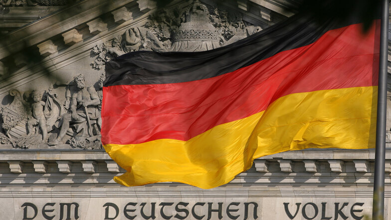 Deutschlandfahne vor dem Reichstag in Berlin.