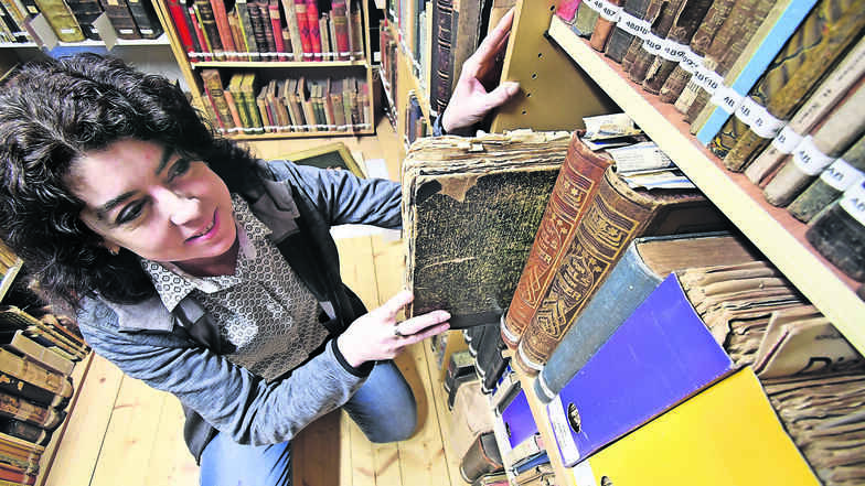 Museumschefin Andrea Bigge zwischen historischen Bänden, die in einer Kammer des Sebnitzer Museums aufbewahrt werden. Im neuen Depot sollen die Bücher künftig bei konstanter Temperatur und Luftfeuchte lagern.