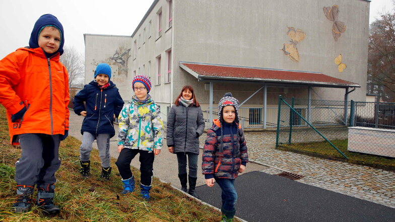 Die Vorschüler Luke, Jonas, Nils und Joel (v.l.) sowie Erzieherin Antje Kühne freut es: Die Außenfassade ihrer Kita Grüner Weg in Elstra soll in diesem Jahr saniert werden.