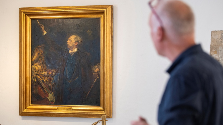 Stadtgalerist Alexander Lange schaut auf ein Gemälde von Robert Sterl, auf dem der Dirigent Ernst Edler von Schuch abgebildet ist.