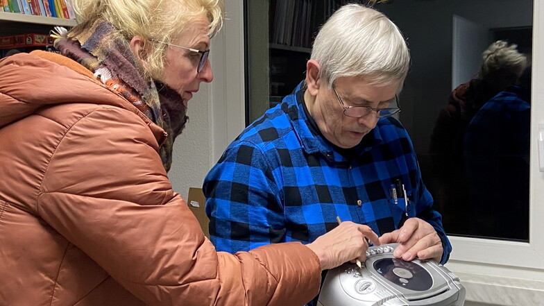 Seit Dienstag gibt es auch in Coswig ein Reparaturcafé: Der ehrenamtliche Helfer Bernd Gröbner (r.) versucht, einer Frau zu helfen.