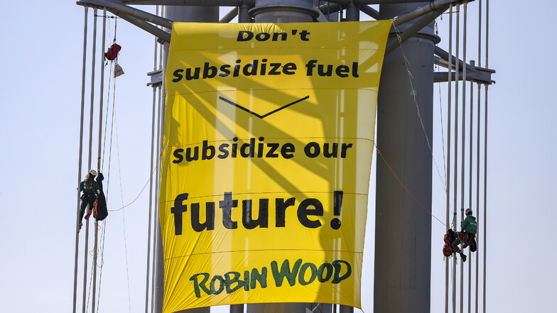 Mitglieder der Umweltschutzorganisation Robin Wood protestieren mit einem großen Banner zum Auftakt des Weltverkehrsforums gegen die Subventionierung fossiler Kraftstoffe.