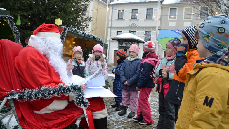 Auf dem Reichenbacher Marktplatz liest der Weihnachtsmann Märchen unterm Tannenbaum.