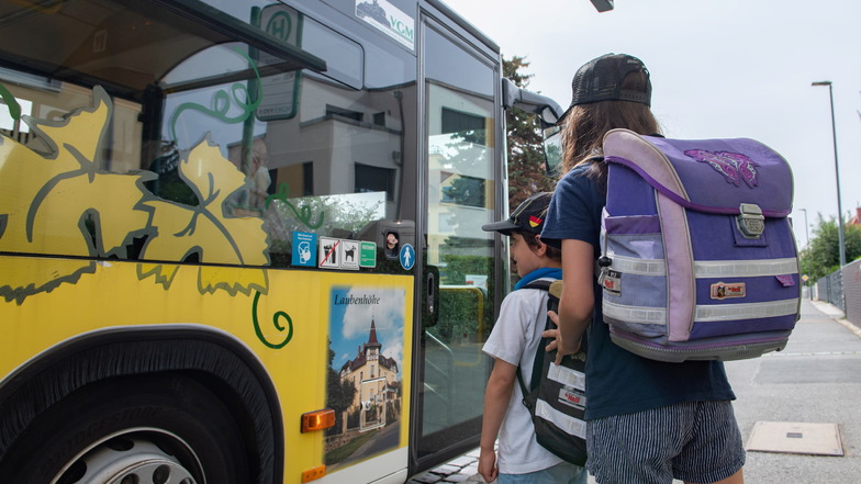 Zwei Schüler steigen in den Schulbus. In Großenhainer Ortsteilen müssen schon Fünftklässler morgens mehrfach umsteigen sind nachmittags über eine Stunde nach Hause unterwegs.