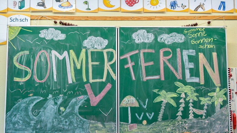 Eine Tafel mit der Aufschrift "Sommerferien" ist im Klassenraum einer Grundschule zu sehen.