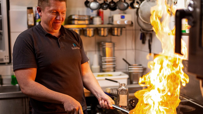 Feuer frei! Mit einem Schuss Fischergeist flambiert Marcel Bark eine Portion Grundeln, Variante naturell, auf dem Herd.