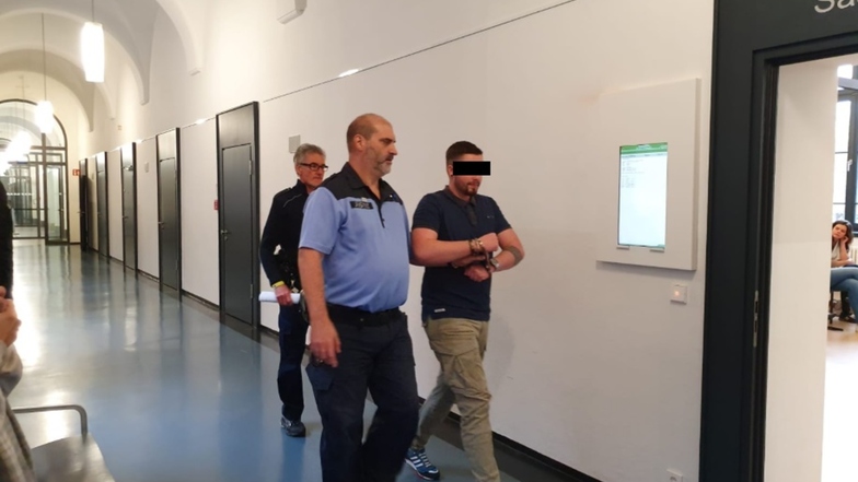 Wachtmeister führen den gefesselten Philip P. in seinen Sitzungssaal am Landgericht Dresden. Der 25-Jährige sitzt seit Mitte Mai in Untersuchungshaft.