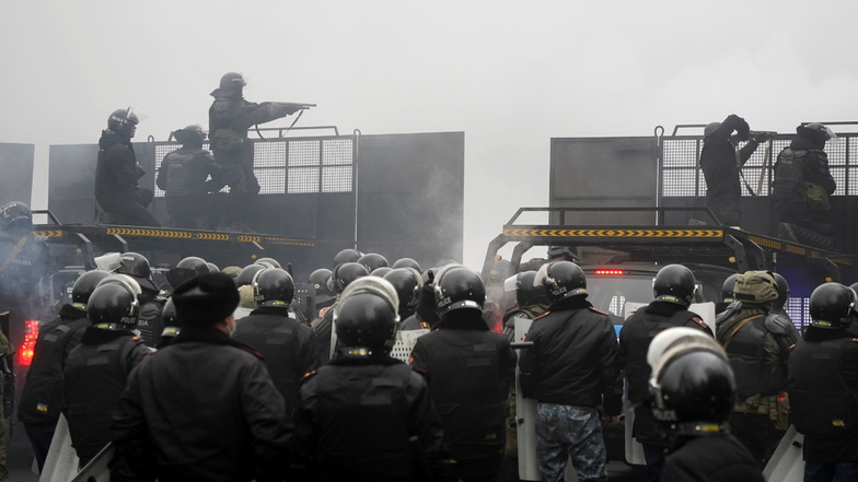 Kasachstan, Almaty: Bereitschaftspolizisten blockieren eine Straße, um Demonstranten aufzuhalten.