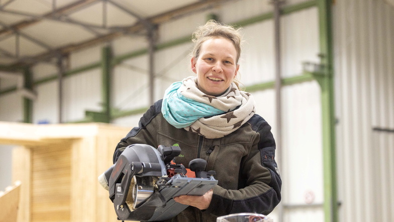 Tischermeisterin Maika Stegmann arbeitet mit einer Säge im Team vom AW Holzhandwerk in Adelsdorf.