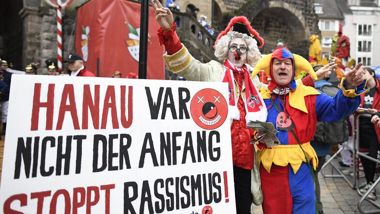 Karnevalisten in Köln erinnern vor Beginn des Rosenmontagszuges an die schrecklichen Ereignisse in Hanau.