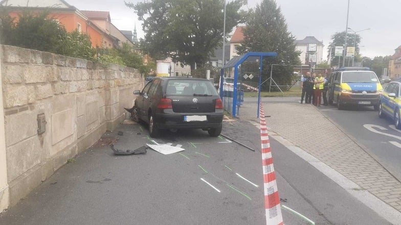 Der VW Golf im Areal der Bushaltestelle Polizei- und Rettungskräfte stehen an der Seite.