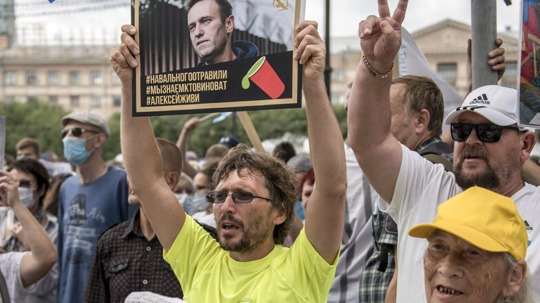 Russland, Khabarovsk: Ein Mann hält bei einer Demonstration ein Plakat mit einem Porträt von dem Oppositionsführer Alexej Nawalny, auf dem zu lesen ist: "Nawalny wurde vergiftet, wir wissen, wer schuld ist, Alexej du musst leben".
